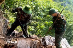 Đội quy tập hài cốt liệt sỹ dùng dụng cụ thô sơ cạy từng tảng đá, tìm kiếm hài cốt liệt sỹ tại Điểm cao 685. (Ảnh: TTXVN phát)