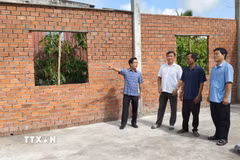Lãnh đạo Ủy ban Nhân dân xã Châu Thới khảo sát tiến độ xây dựng nhà tình nghĩa cho người có công. (Ảnh: Tuấn Kiệt/TTXVN)