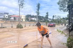 Người dân phố Cũ (phường Thục Phán) khẩn trương thu dọn vệ sinh, sớm ổn định lại cuộc sống. (Ảnh: Chu Hiệu/TTXVN)