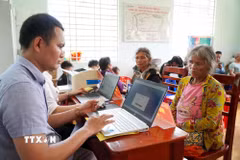 Người dân tộc Cor ở thôn Trà Thanh, xã Thanh Bồng (Quảng Ngãi) được thành viên Tổ công tác lưu động hỗ trợ thực hiện thủ tục hành chính. (Ảnh: Lê Phước Ngọc/TTXVN)