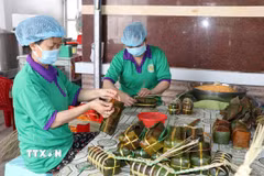 Người lao động làm bánh tét tại cơ sở sản xuất bánh tét Ba Loan, làng nghề bánh tét Trà Cuôn. (Ảnh: Thanh Hòa/TTXVN)