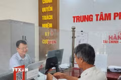Công chức phường Mạo Khê, Quảng Ninh, hướng dẫn công dân nộp hồ sơ chứng thực lên Cổng dịch vụ công Quốc gia. (Ảnh: Thanh Vân/TTXVN)