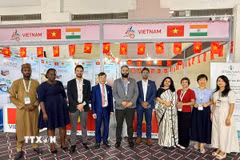 Tham tán Thương mại Bùi Trung Thướng (thứ 4 từ trái sang) chụp ảnh lưu niệm của các quan khách trong và ngoài nước tới tham quan gian hàng. (Ảnh: Ngọc Thúy/TTXVN)