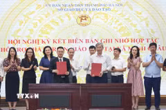 Đại diện Trường Tiểu học, Trung học Cơ sở và Trung học Phổ thông Minh Châu cùng đại diện Trường Tiểu học, Trung học Cơ sở và Trung học Phổ thông Dewey Cầu Giấy thực hiện ký kết, trao biên bản ghi nhớ hợp tác. (Ảnh: Thanh Tùng/TTXVN)