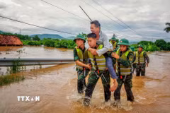 Cán bộ chiến sỹ Sư đoàn 325 hỗ trợ người dân trên địa bàn xã Nam Dương di dời. (Ảnh: Danh Lam/TTXVN)