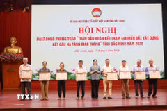 Khen thưởng các hộ gia đình tiêu biểu có nhiều thành tích trong hiến đất làm đường. (Ảnh: Thanh Thương/TTXVN)