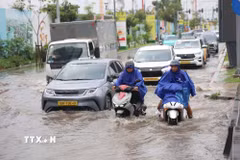Các phương tiện lưu thông qua đoạn đường ngập nặng chân cầu Ba Son, phường An Khánh, sau cơn mưa lớn trưa 6/10. (Ảnh: Hồng Đạt/TTXVN)