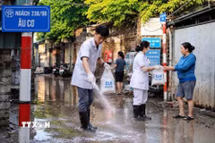 Cán bộ y tế phường Hồng Hà tham gia vệ sinh môi trường cùng người dân. (Ảnh: Kim Anh/TTXVN)