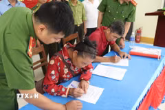Cán bộ Công an xã Yên Na (Nghệ An) hướng dẫn người dân hoàn thiện các thủ tục ký cam kết chấp hành pháp luật, không khai thác vàng trái phép tại khu vực khe Huổi Lúc và các địa bàn lân cận. (Ảnh: Văn Tý/TTXVN)