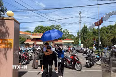 Cán bộ chiến sỹ Trung đoàn cảnh sát cơ động hỗ trợ cõng học sinh bị gãy chân đi thi. (Ảnh: Sỹ Thắng/TTXVN)
