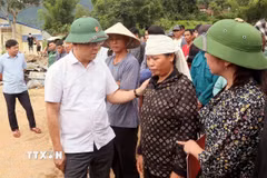 Phó Thủ tướng Chính phủ Lê Thành Long thăm hỏi, động viên gia đình bị thiệt hại về người do mưa lũ ở xã Chiềng Sơ. (Ảnh: Quang Quyết/ TTXVN)