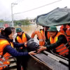 Đại tá Nguyễn Văn Hòa, Phó Tham mưu trưởng Quân khu 5, trực tiếp trao nhu yếu phẩm thiết yếu cho người dân vùng ngập lũ. (Ảnh: Đoàn Hữu Trung/TTXVN)