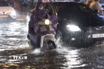 Người dân Thành phố Hồ Chí Minh di chuyển trong mưa và ngập tối 30/9. (Ảnh: Hồng Đạt/TTXVN)