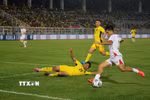 Nỗ lực đi bóng của Văn Vĩ trước sự truy cản của cầu thủ Malaysia. (Ảnh: Thanh Bình/TTXVN)