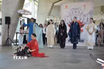 Ca sỹ Thanh Lam (áo đen đứng giữa) hát nền trong phần trình diễn áo dài của nhà thiết kế Minh Hạnh tại sự kiện. (Ảnh: Hữu Chiến/TTXVN)