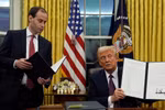 Tổng thống Mỹ Donald Trump (phải) ký sắc lệnh hành pháp ngay sau lễ nhậm chức, tại Nhà Trắng ở Washington DC., ngày 20/1/2025. (Ảnh: AP/TTXVN)