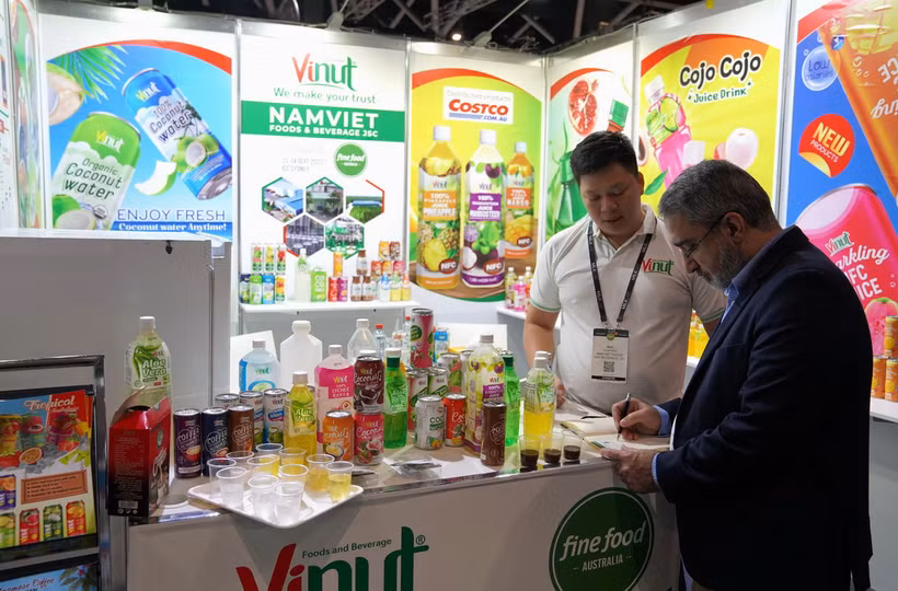 Khách tham quan tìm hiểu về thông tin các doanh nghiệp đồ uống Việt Nam tại một hội chợ. (Nguồn: TTXVN)