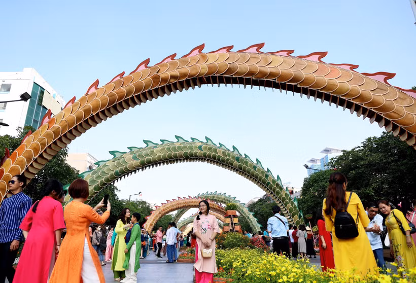 Khách tham quan và chụp ảnh check-in tại Đường hoa Nguyễn Huệ. (Ảnh: Hồng Đạt/TTXVN)