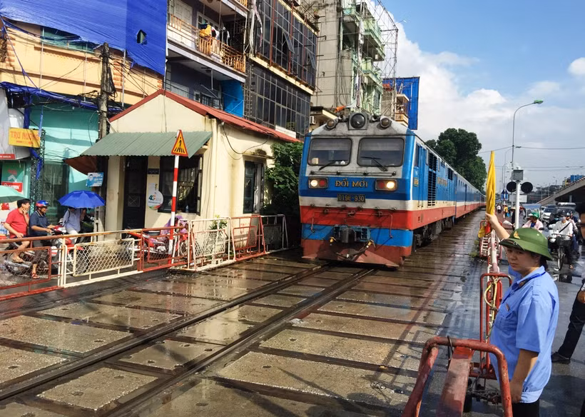 Nhân viên gác chắn đường sắt thực hiện công tác đảm bảo an toàn chạy tàu. (Ảnh: Việt Hùng/Vietnam+)