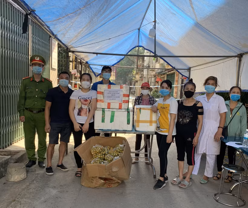 Nhóm Thiện Từ Tâm ở thị trấn Yên Viên, huyện Gia Lâm (Hà Nội) trao quà ủng hộ bà con Tổ dân phố cơ khí Yên Viên bị phong tỏa do dịch COVID-19. (Ảnh: TTXVN phát)
