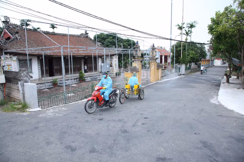 Phun thuốc khử trùng tiêu độc tại khu vực liên quan đến các ca dương tính với SARS-CoV-2 tại huyện Vĩnh Bảo ngày 24/6. (Ảnh: TTXVN)