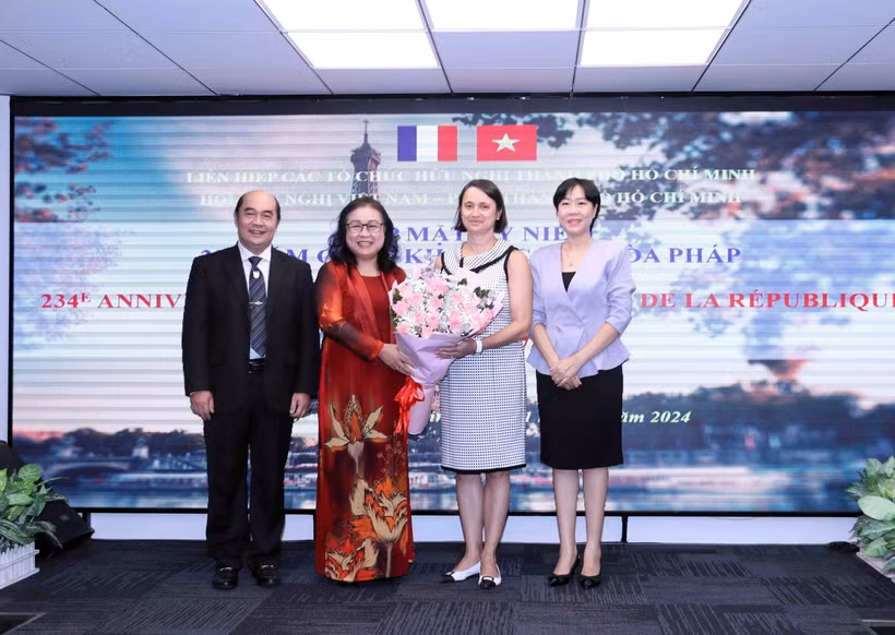 Đại diện lãnh đạo HUFO và Hội hữu nghị Việt Nam- Pháp Thành phố Hồ Chí Minh tặng hoa chúc mừng bà Emmanuelle Pavillon-Grosser (thứ 2, từ phải sang), Tổng Lãnh sự Cộng hòa Pháp tại Thành phố Hồ Chí Minh. (Ảnh: Xuân Khu/TTXVN)