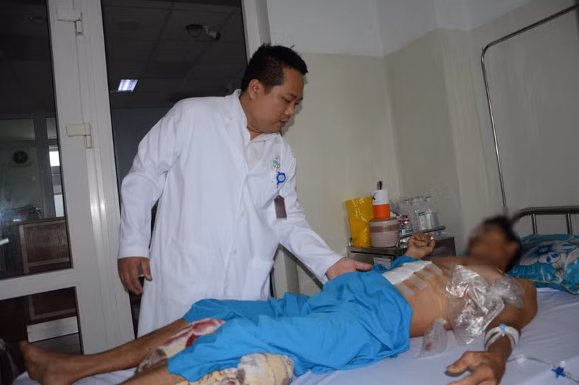 Bác sỹ Chuyên khoa II Nguyễn Văn Hải Vân khám cho bệnh nhân sau phẫu thuật. (Ảnh: Văn Dũng/TTXVN)