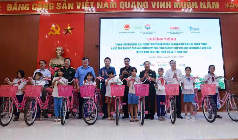 Đoàn công tác trao xe đạp và quà tặng trẻ em có hoàn cảnh khó khăn xã Chiêu Lưu. (Ảnh: Lâm Khánh/Vietnam+)