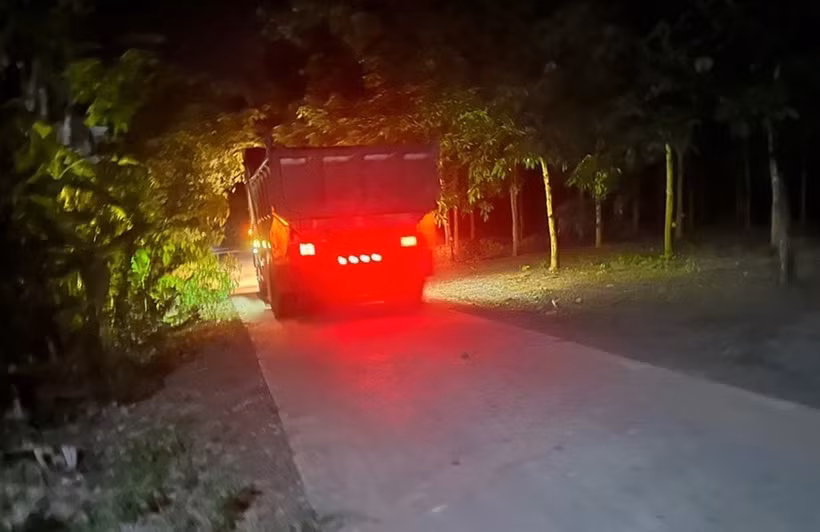 Xe ben chở đất khai thác trái phép trong đêm. (Ảnh: TTXVN phát)