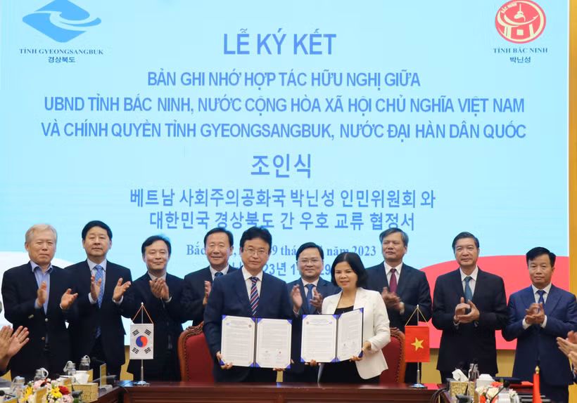 Ông Lee Cheol Woo, Tỉnh trưởng tỉnh Gyeongsangbuk và Chủ tịch UBND tỉnh Bắc Ninh Nguyễn Hương Giang ký kết biên bản ghi nhớ trước sự chứng kiến của lãnh đạo 2 địa phương. (Ảnh: Thanh Thương/TTXVN)