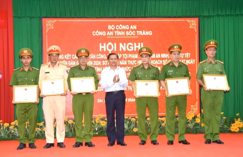 Chủ tịch UBND tỉnh Sóc Trăng Trần Văn Lâu trao Bằng khen của UBND tỉnh cho 1 tập thể và 5 cá nhân có thành tích xuất sắc trong vụ việc giải cứu con tin. (Ảnh: TTXVN phát)