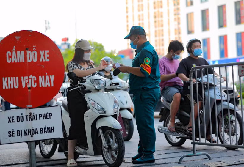 Các chốt kiểm soát của Ban chỉ đạo phòng chống dịch phường Vĩnh Tuy kiếm tra giấy tờ, thông tin của người ra, vào trên địa bàn. (Ảnh: Thanh Tùng/TTXVN)