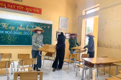 Các thầy, cô giáo Trường Tiểu học Phú Hòa sắp xếp bàn ghế tại nơi học tạm chuẩn bị năm học mới. (Ảnh: Thái Hùng/TTXVN)
