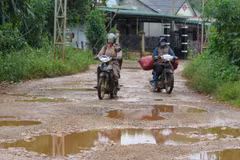"Ổ gà", "ổ voi" chằng chịt, dày đặc trên mặt đường bị mất lớp nhựa của tuyến đường DH85, gây khó khăn cho các phương tiện giao thông. (Ảnh: Dư Toán/TTXVN)
