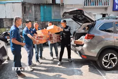 Anh Lỗ Minh Tuấn, Đội trưởng “Đội xe 0 đồng Hà Nội” cùng Tình nguyện viên tiếp nhận hàng hỗ trợ do các tổ chức, cá nhân quyên góp. (Ảnh: Lê Đông/TTXVN)