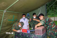 Lực lượng chức năng số hóa thông tin quá trình lấy mẫu giám định, xác định danh tính hài cốt liệt sỹ. (Ảnh: Chu Hiệu/TTXVN)
