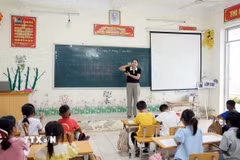 Giáo viên Trường Phổ thông Dân tộc Bán trú Tiểu học và Trung học cơ sở Thu Lũm hướng dẫn học sinh lớp 1 cách cầm bút. (Ảnh: Quý Trung/TTXVN)