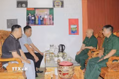 Lãnh đạo Hội Cựu chiến binh xã Hưng Khánh và cán bộ xã thăm thương binh Đào Đức Chỉ, thôn Hồng Hải, xã Hưng Khánh (Lào Cai). (Ảnh: Đinh Thùy/TTXVN)