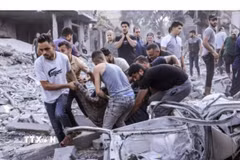 Chuyển thi thể người Palestine thiệt mạng sau các cuộc không kích của Israel xuống Dải Gaza. (Ảnh: IRNA/TTXVN phát)