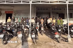 Nhóm thanh, thiếu niên tụ tập "đi bão" lúc rạng sáng cùng phương tiện được đưa về trụ sở Công an. (Ảnh: TTXVN phát)