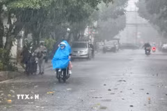 Người dân mặc đồ bảo hộ chống nắng khi di chuyển trên đường. (Ảnh: Nguyên Lý/TTXVN)