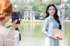 Người dân, du khách tranh thủ ghi lại những kỷ niệm đẹp bên hồ Hoàn Kiếm nhân Ngày Phụ nữ Việt Nam 20/10. (Ảnh: Lê Đông/TTXVN)