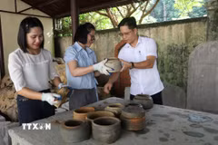 Cán bộ Bảo tàng tỉnh Ninh Bình tiến hành làm sạch và nghiên cứu sơ bộ các hiện vật lon sành thời Trần. (Ảnh: Hải Yến/TTXVN)