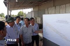 Lãnh đạo thành phố kiểm tra sơ đồ giải phóng mặt bằng thuộc dự án đầu tư xây dựng công trình Đường Dương Minh Quan. (Ảnh: Trung Kiên/TTXVN)