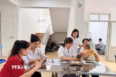 Người dân xã Đạo Trù được cán bộ y tế xã hướng dẫn cài đặt, sử dụng Sổ sức khoẻ điện tử. (Ảnh: Nguyễn Thảo/TTXVN)