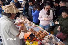 Một nghệ nhân làm bánh Pan de muerto tại thủ đô Mexico City trực tiếp giao sản phẩm cho khách hàng. (Ảnh: Phi Hùng/TTXVN)