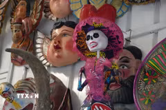 Một mô hình Catrina-người phụ nữ với chiếc mũ rộng vành, váy áo lộng lẫy và gương mặt hóa trang thành hộp sọ trong một quầy bánh Pan de muerto tại thủ đô Mexico City, Mexico. (Ảnh: Phi Hùng/TTXVN)
