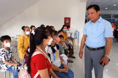 Phó Chủ tịch Ủy ban Nhân dân tỉnh Long An Phạm Tấn Hoà thăm hỏi các gia đình đưa trẻ em đến khám sàng lọc bệnh tim bẩm sinh. (Ảnh: Đức Hạnh/TTXVN)