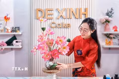 Sản phẩm hoàn thiện là sự kết hợp giữa hai kỹ thuật tạo hình: phần bình được làm từ bánh Trung Thu, trong khi những cành sen phía trên được nặn thủ công từ bột tò he. Sự kết hợp này tạo cho chiếc bánh Trung thu dáng vẻ như một bình hoa nghệ thuật. (Ảnh: Phạm Tuấn Anh/TTXVN)