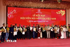 Đại diện Ban chấp hành Hội Nhà văn Việt Nam trao quyết định kết nạp hội viên mới. (Ảnh: Phương Lan/TTXVN)